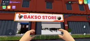 First-person view of the Bakso Store sign on an orange shopfront with a hand pointing at it
