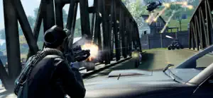 A soldier firing from under a steel bridge during a multiplayer match