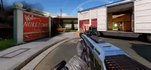 First-person rifle aimed at the Nuketown sign beside a parked truck