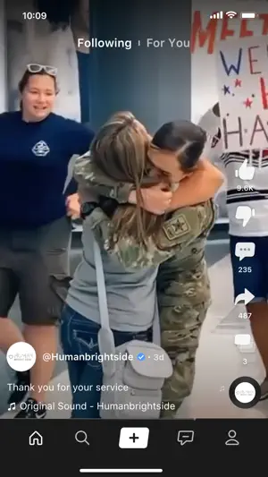 Following feed playing a homecoming video of a soldier in uniform hugging a woman, with like, dislike, comment and share buttons