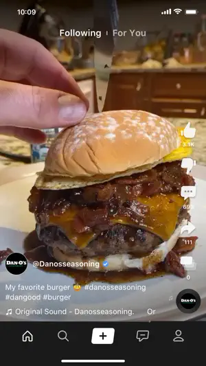 Close-up food video of a cheeseburger with onions from @Danosseasoning above the home, search, post, messages and profile bar