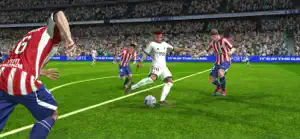 A striker shielding the ball from a defender in a floodlit stadium