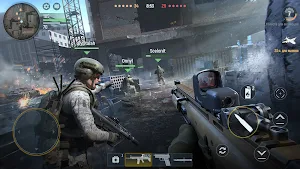 Two soldiers advancing past a red-dot rifle in a bombed urban square with team markers