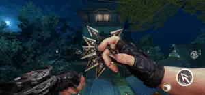 A hand holding a throwing star in a night-time garden