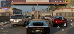 Supercars and a red coupe stopped at a Los Angeles crossroads with the city HUD on screen