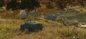 An off-road vehicle parked in an autumn valley beside a stream
